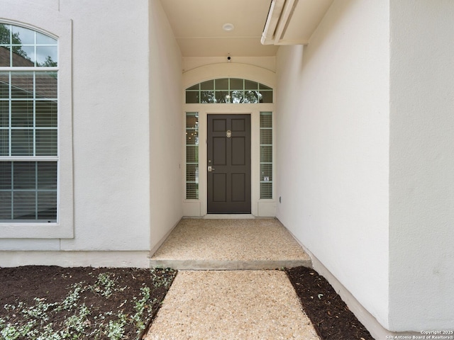 view of exterior entry featuring stucco siding