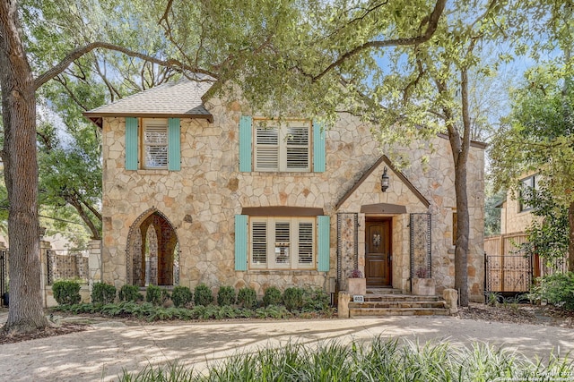 402 Thelma Dr, Olmos Park, TX 78212 - tudor house with roof with shingles, fence, and stone siding
