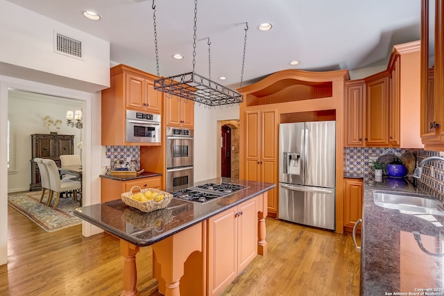 402 Thelma Dr, Olmos Park, TX 78212 - kitchen with decorative backsplash, visible vents, a center island, a sink, and stainless steel appliances