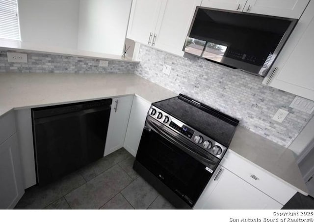 kitchen featuring backsplash, stainless steel microwave, electric stove, black dishwasher, and white cabinetry
