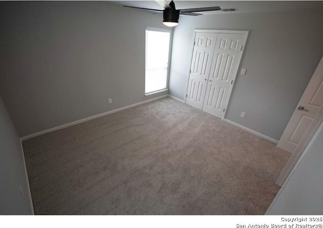 unfurnished bedroom with a closet, a ceiling fan, carpet, and baseboards