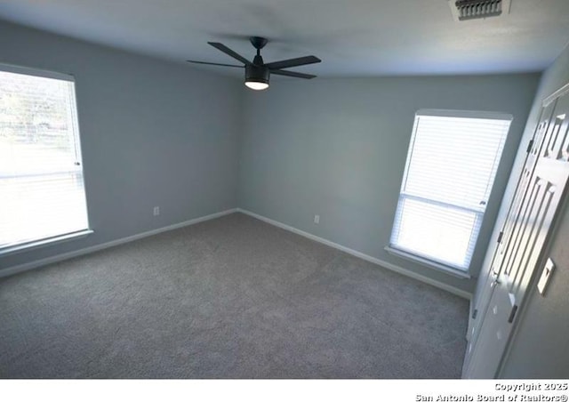spare room with plenty of natural light, carpet, a ceiling fan, and visible vents