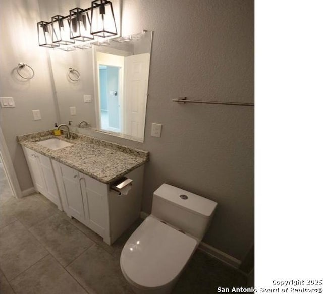 bathroom with toilet, tile patterned flooring, and vanity
