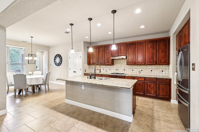 kitchen featuring a sink, decorative backsplash, under cabinet range hood, and stainless steel appliances