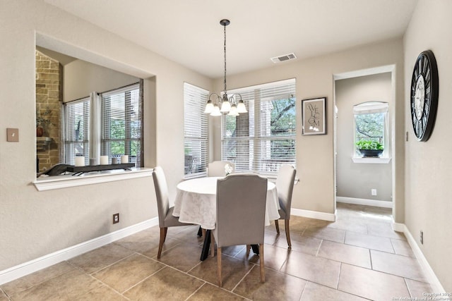 dining area featuring baseboards, plenty of natural light, a notable chandelier, and visible vents