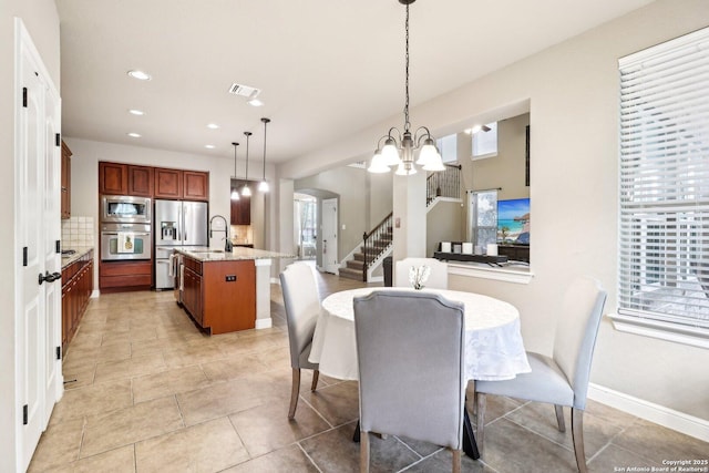 dining room with a notable chandelier, arched walkways, recessed lighting, baseboards, and visible vents