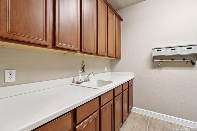 laundry room featuring baseboards and a sink
