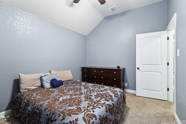 carpeted bedroom with visible vents, a textured wall, baseboards, a ceiling fan, and vaulted ceiling