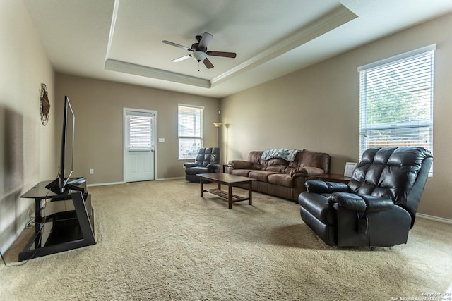 living area with carpet floors, a tray ceiling, and a wealth of natural light