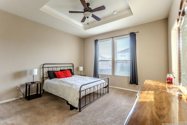 bedroom with a raised ceiling, baseboards, ornamental molding, and carpet