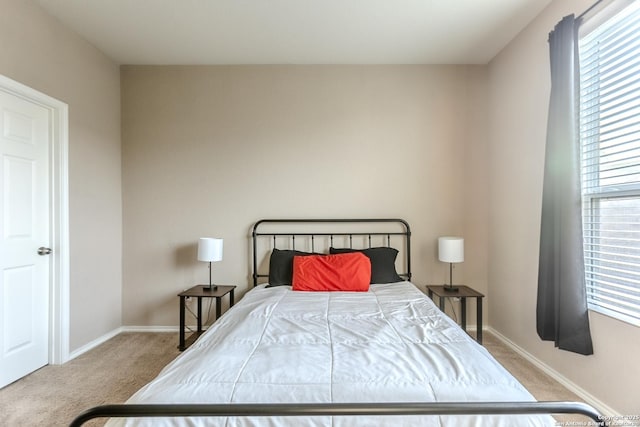 bedroom with baseboards and carpet