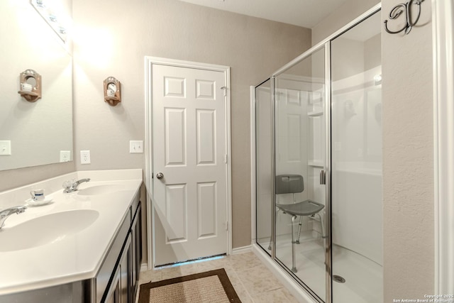 bathroom featuring double vanity, a sink, and a stall shower