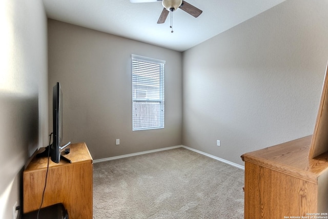 unfurnished office with carpet floors, baseboards, and a ceiling fan