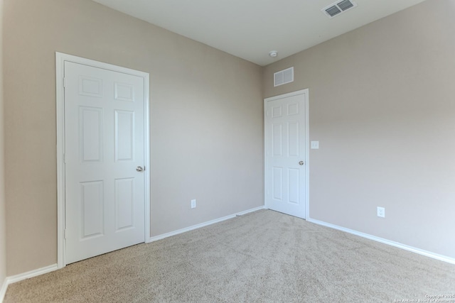 spare room with baseboards, carpet, and visible vents