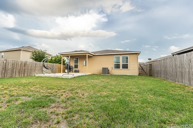 back of property with a lawn, a fenced backyard, a patio area, and central AC unit