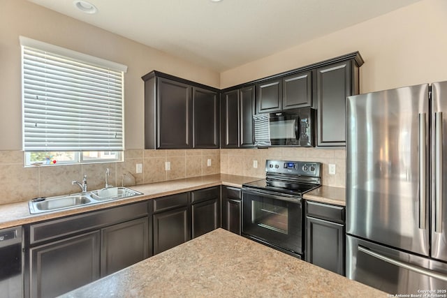 kitchen with light countertops, a sink, black appliances, and tasteful backsplash