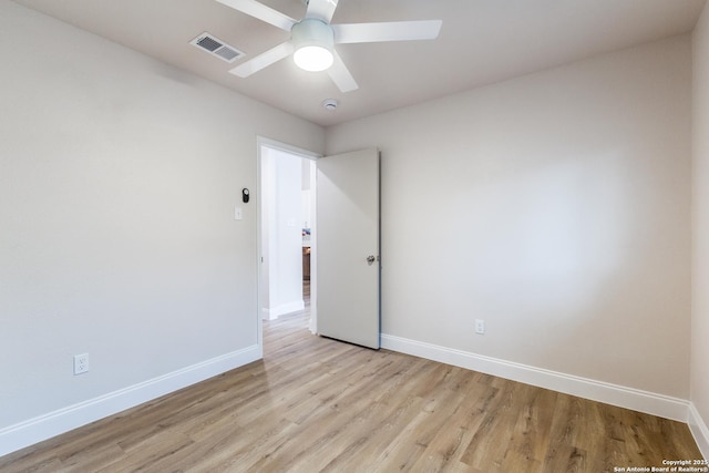 unfurnished room with baseboards, a ceiling fan, light wood-style flooring, and visible vents