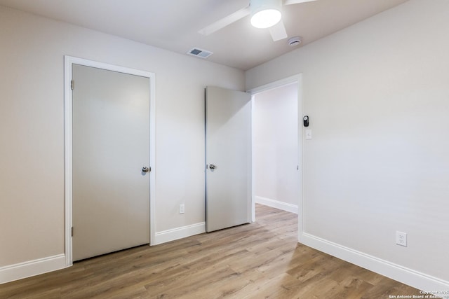 unfurnished bedroom featuring ceiling fan, baseboards, visible vents, and light wood-style flooring
