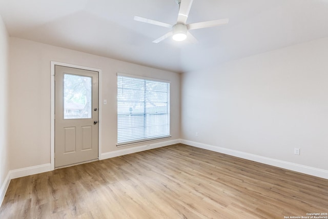 foyer entrance with baseboards, ceiling fan, and light wood finished floors