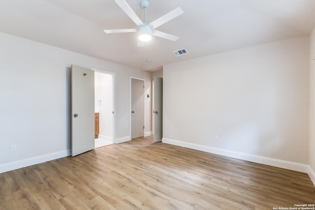 empty room featuring baseboards, ceiling fan, light wood-style flooring, and visible vents