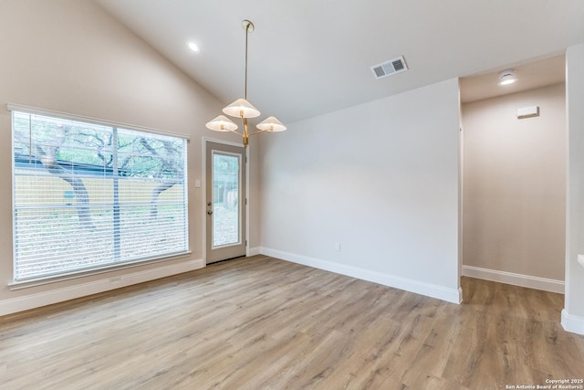 empty room with visible vents, a wealth of natural light, and light wood-type flooring