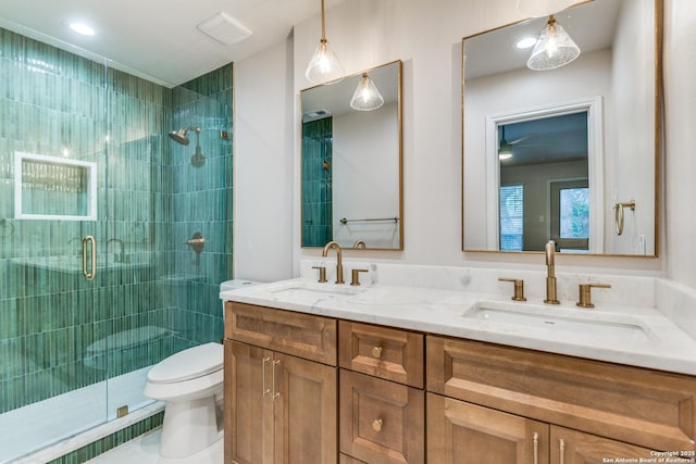 full bath featuring double vanity, toilet, a shower stall, and a sink