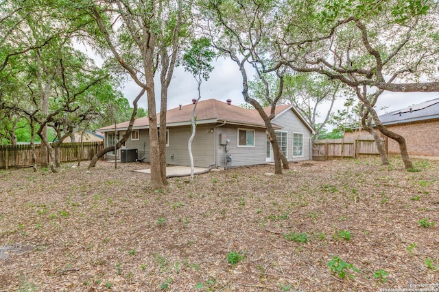 back of property with a fenced backyard, a patio area, and central air condition unit