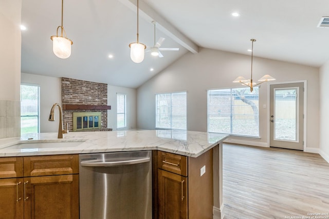 kitchen with stainless steel dishwasher, a sink, brown cabinets, and open floor plan