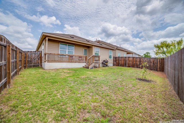 back of house with a lawn and a fenced backyard