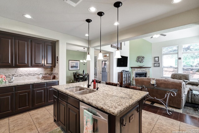 3811 Valencia Ct, San Antonio, TX 78259 - kitchen with a sink, stainless steel dishwasher, open floor plan, decorative backsplash, and light stone countertops