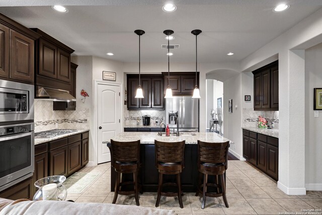 3811 Valencia Ct, San Antonio, TX 78259 - kitchen with stainless steel appliances, arched walkways, tasteful backsplash, light tile patterned flooring, and recessed lighting