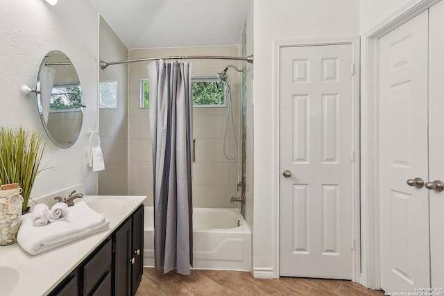 full bath featuring vanity, lofted ceiling, wood finished floors, and shower / tub combo with curtain
