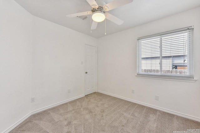 empty room with a ceiling fan, baseboards, visible vents, and light carpet