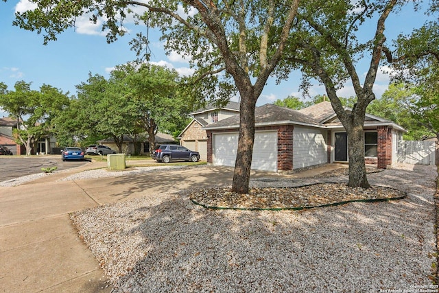 view of side of home with brick siding, an attached garage, fence, and driveway