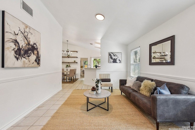 living room featuring visible vents, light tile patterned floors, baseboards, a notable chandelier, and lofted ceiling
