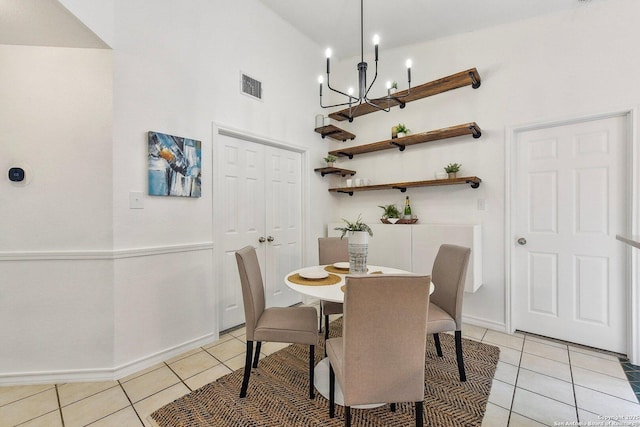 dining space featuring light tile patterned floors, baseboards, visible vents, and a chandelier