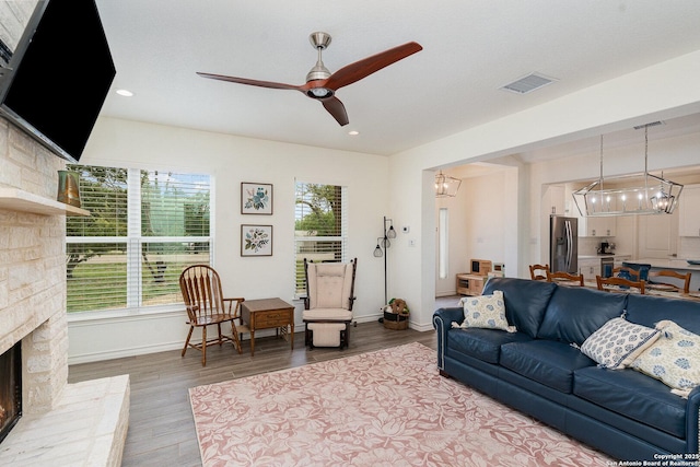 1420 Persimmon Pass, Fischer, TX 78623 - living area with baseboards, visible vents, wood finished floors, and ceiling fan with notable chandelier