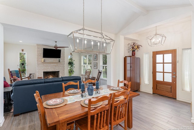 1420 Persimmon Pass, Fischer, TX 78623 - dining space featuring an inviting chandelier, vaulted ceiling with beams, light wood-style floors, and a fireplace