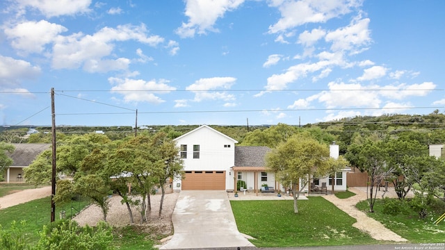 1420 Persimmon Pass, Fischer, TX 78623 - view of front of home featuring concrete driveway, a chimney, a front lawn, and a garage