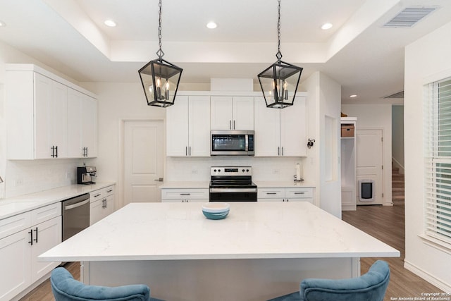 1420 Persimmon Pass, Fischer, TX 78623 - kitchen featuring a breakfast bar, stainless steel appliances, light wood-type flooring, and visible vents
