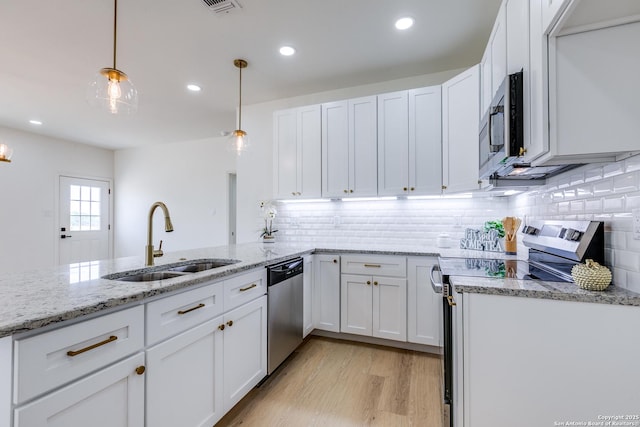 kitchen featuring backsplash, white cabinetry, appliances with stainless steel finishes, and a sink