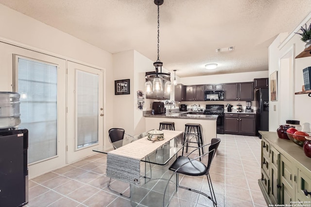 dining room with light tile patterned flooring, a textured ceiling, an inviting chandelier, and visible vents