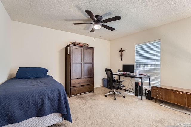 bedroom featuring a textured ceiling, light colored carpet, and ceiling fan