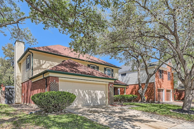 traditional-style house featuring concrete driveway, brick siding, a chimney, and a garage