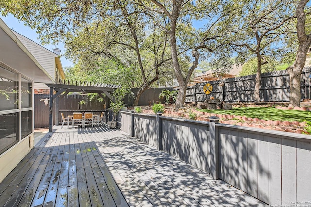 deck featuring a pergola, a fenced backyard, and outdoor dining space