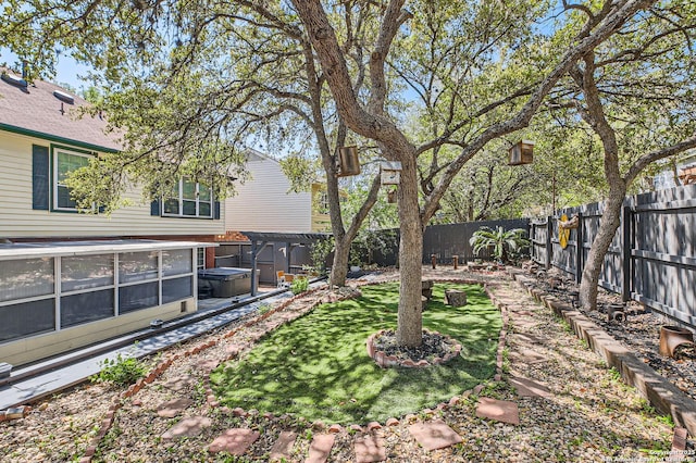 view of yard featuring a hot tub and a fenced backyard