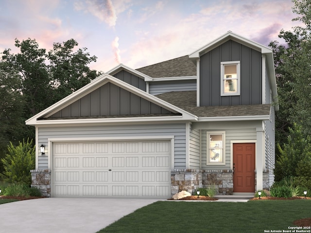 view of front of home featuring roof with shingles, stone siding, board and batten siding, concrete driveway, and a lawn