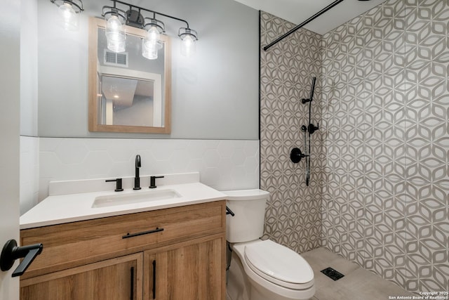 66 Brees Blvd Unit 125, San Antonio, TX 78209 - full bath featuring vanity, wainscoting, toilet, tile walls, and tiled shower