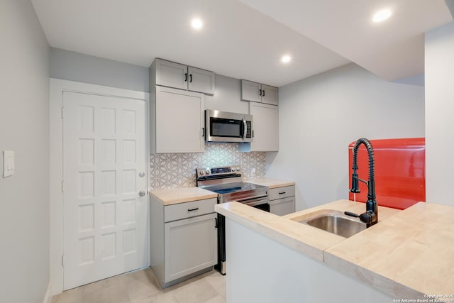 66 Brees Blvd Unit 125, San Antonio, TX 78209 - kitchen featuring gray cabinets, backsplash, appliances with stainless steel finishes, a sink, and light countertops