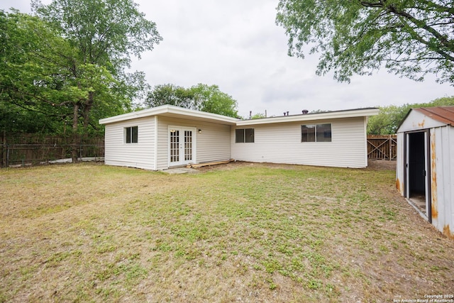 5154 Village Grn, San Antonio, TX 78218 - rear view of property featuring french doors, an outdoor structure, a lawn, and a fenced backyard